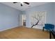 Bedroom with wood floors, blue chair, and closet with painted cherry blossom design at 15630 N Himes Ave, Tampa, FL 33618