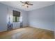 Light-filled bedroom with hardwood floors, ceiling fan, and floral curtains at 15630 N Himes Ave, Tampa, FL 33618