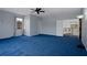 Large bonus room with soft blue walls, blue carpet and ceiling fan at 15630 N Himes Ave, Tampa, FL 33618