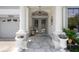 Grand entryway with a gray double door, marble floors, and elegant plants at 15630 N Himes Ave, Tampa, FL 33618