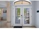Elegant double front door with decorative glass panels, transom window, and bright interior at 15630 N Himes Ave, Tampa, FL 33618
