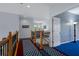 Hallway with hardwood floors, patterned rugs, wood banister, and a view into another room at 15630 N Himes Ave, Tampa, FL 33618
