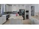 Modern kitchen features stainless steel appliances, a central island, and sleek white cabinetry at 15630 N Himes Ave, Tampa, FL 33618