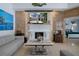 Elegant living room with marble fireplace, a plush gray sofa, and an open view to the bedroom at 15630 N Himes Ave, Tampa, FL 33618