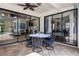 Covered patio with outdoor dining set and multiple sliding glass doors overlooking the lush backyard at 15630 N Himes Ave, Tampa, FL 33618