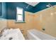 Vintage bathroom with blue accent walls and yellow tile at 1665 Laura St, Clearwater, FL 33755