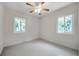 A serene bedroom with dual windows and modern ceiling fan at 1665 Laura St, Clearwater, FL 33755