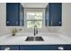 Kitchen sink with a view from the window surrounded by navy cabinets and white countertops at 1665 Laura St, Clearwater, FL 33755