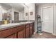 Bathroom featuring a dual sink vanity with granite countertop and dark wood cabinets at 16930 Red Brick Ln, Land O Lakes, FL 34638