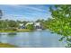 Community clubhouse and lake with manicured lawns surrounded by lush trees at 16930 Red Brick Ln, Land O Lakes, FL 34638
