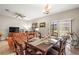 Open dining area with tile flooring, a wooden dining table, slider door to the outdoors, and a connected living space at 16930 Red Brick Ln, Land O Lakes, FL 34638