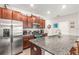 Spacious kitchen with stainless steel appliances, granite counters, wood cabinetry, and a functional center island at 16930 Red Brick Ln, Land O Lakes, FL 34638