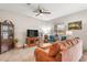 Inviting living room with neutral walls, tile flooring, a ceiling fan, and comfortable seating arrangements at 16930 Red Brick Ln, Land O Lakes, FL 34638