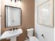 Powder room featuring pedestal sink, designer mirror, and neutral color scheme at 17030 Moonflower Dr, Venice, FL 34293