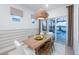 Inviting dining area with a wood table, stylish light fixture, and a view of the outdoor pool area at 17030 Moonflower Dr, Venice, FL 34293