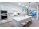 Modern kitchen with white cabinets, stainless steel appliances, and a quartz countertop island with seating at 17030 Moonflower Dr, Venice, FL 34293