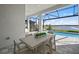Outdoor dining area adjacent to a refreshing pool and lush backyard with serene lake views at 17030 Moonflower Dr, Venice, FL 34293
