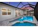 Inviting pool area with clear water, a relaxing spa, and an enclosed patio at 17030 Moonflower Dr, Venice, FL 34293
