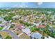 An aerial view highlights the property's pool surrounded by a lush green yard in a quiet neighborhood at 1859 Northview Rd, Largo, FL 33770