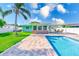 Backyard view of a charming home featuring a pool, patio, and well-maintained landscaping at 1859 Northview Rd, Largo, FL 33770