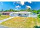 Charming single-story home with a well-maintained lawn, long driveway and white fence in a sunny neighborhood at 1859 Northview Rd, Largo, FL 33770