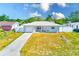 Charming single-story home with a well-maintained lawn, long driveway and white fence in a sunny neighborhood at 1859 Northview Rd, Largo, FL 33770