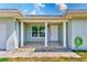 Inviting front porch with decorative columns, tile flooring, and a neatly maintained green hose at 1859 Northview Rd, Largo, FL 33770