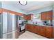 Bright kitchen with stainless steel appliances, wood cabinets, and natural light from the window at 1859 Northview Rd, Largo, FL 33770