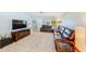 Spacious living room featuring neutral tile floors, a large leather sofa, and abundant natural light at 1859 Northview Rd, Largo, FL 33770
