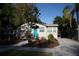 Charming single-story home featuring a bright turquoise door, manicured landscaping, and a brick paved walkway and driveway at 1914 53Rd S St, Gulfport, FL 33707