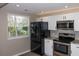Well-lit kitchen showcasing black stainless steel appliances, white shaker cabinets, granite countertops, and modern subway tile at 1914 53Rd S St, Gulfport, FL 33707