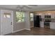 Spacious living room with a view of a modern kitchen featuring black appliances, white cabinets, and wood-look flooring at 1914 53Rd S St, Gulfport, FL 33707