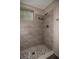Nicely tiled walk-in shower featuring neutral tones, pebble floor and built in storage at 1914 53Rd S St, Gulfport, FL 33707