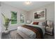 Comfortable bedroom with large windows, stylish decor, and a queen-sized bed with neutral bedding at 19486 Sheltered Hill Dr, Brooksville, FL 34601