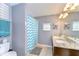 Bathroom featuring double sinks, granite countertop and a blue chevron shower curtain at 19533 Whispering Brook Dr, Tampa, FL 33647