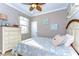 Cozy bedroom with a seashell theme, ceiling fan, and a view of a window at 19533 Whispering Brook Dr, Tampa, FL 33647
