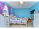 Bright bedroom featuring blue walls, a ceiling fan, and ample natural light from the window at 19533 Whispering Brook Dr, Tampa, FL 33647