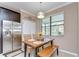 Bright dining area with a wooden table, stylish chandelier, and stainless steel refrigerator at 19533 Whispering Brook Dr, Tampa, FL 33647