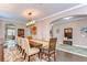 Open-concept dining room featuring hardwood floors, seating for eight, and modern lighting at 19533 Whispering Brook Dr, Tampa, FL 33647