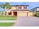 Charming two-story home featuring a three-car garage and brick-paved driveway at 19533 Whispering Brook Dr, Tampa, FL 33647