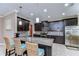 Modern kitchen with dark cabinets, stainless steel appliances, granite countertops, and island seating at 19533 Whispering Brook Dr, Tampa, FL 33647