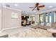 Cozy living room with a sectional sofa, ceiling fan, and view of the kitchen and outdoor area at 19533 Whispering Brook Dr, Tampa, FL 33647