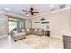 Inviting living room with a sectional sofa, ceiling fan, and sliding glass doors to the pool area at 19533 Whispering Brook Dr, Tampa, FL 33647