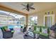 Relaxing covered patio with ceiling fan, outdoor seating, and views of the backyard and pool at 19533 Whispering Brook Dr, Tampa, FL 33647