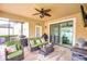 Covered patio featuring comfortable seating, ceiling fan, and a view of the backyard at 19533 Whispering Brook Dr, Tampa, FL 33647