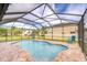 Lovely backyard view of a screened-in pool with brick pavers and comfortable lounge chairs at 19533 Whispering Brook Dr, Tampa, FL 33647