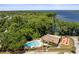 Aerial view showcases a community pool, clubhouse, and picnic area near a serene lake at 2212 Lark W Cir # E, Palm Harbor, FL 34684