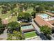 An aerial view showcasing a community with pool, shuffleboard courts, and parking at 2212 Lark W Cir # E, Palm Harbor, FL 34684