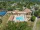 Beautiful aerial view of community center, pool, and tennis courts surrounded by trees at 2212 Lark W Cir # E, Palm Harbor, FL 34684