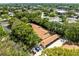 An aerial view showcasing roof and car port with ample parking among lush green trees at 2212 Lark W Cir # E, Palm Harbor, FL 34684
